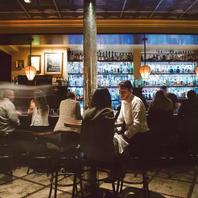 Um casal toma uma bebida em um bar movimentado de São Francisco.